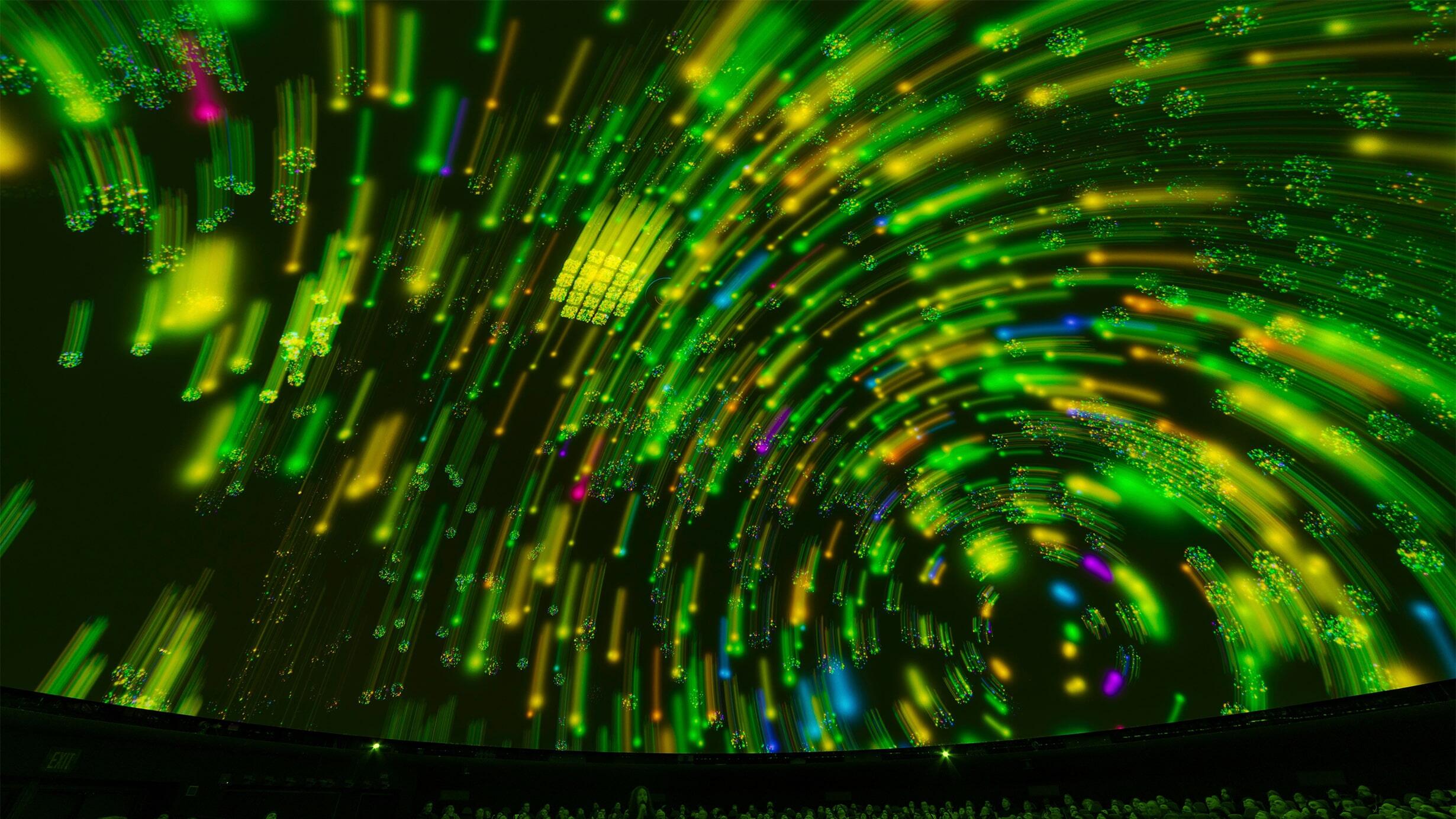 A digital rendering of stars' movement through the solar system, their paths depicted in bright green arcs, projected onto the Hayden Planetarium.