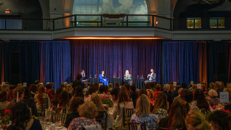 Seated visitors view a panel onstage in the Museum's Hall of Ocean Life.