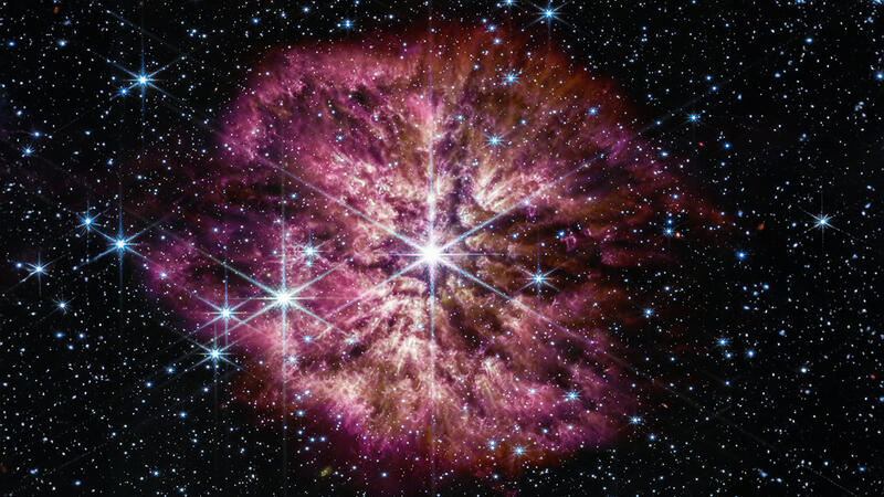 A luminous hot star in space against background of other stars and galaxies.