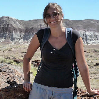 Emily Hopper leans against a rocky outcrop during a pause in her field work.