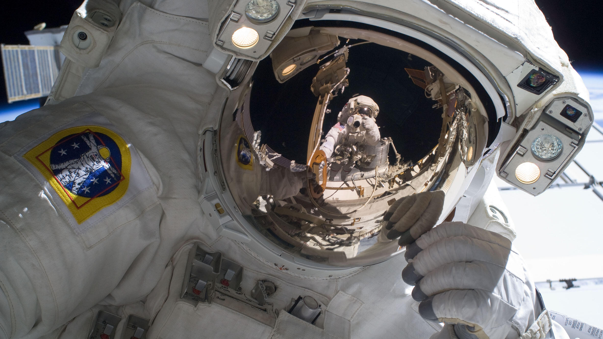 A close look at the helmet visor of STS-129 Mission Specialist Mike Foreman shows the reflection of his crewmate, Mission Specialist Randy Bresnik.