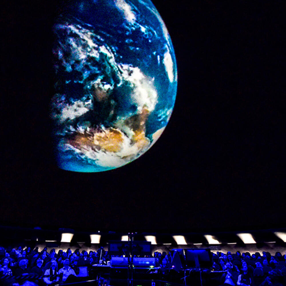 Seated Museum visitors view 360 projections of space inside the Hayden Planetarium. 