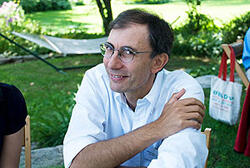 Photo of astronomer Dimitar Sasselov sitting in a yard