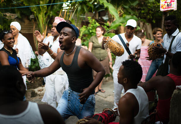 A large crowd of worshippers chant and dance.