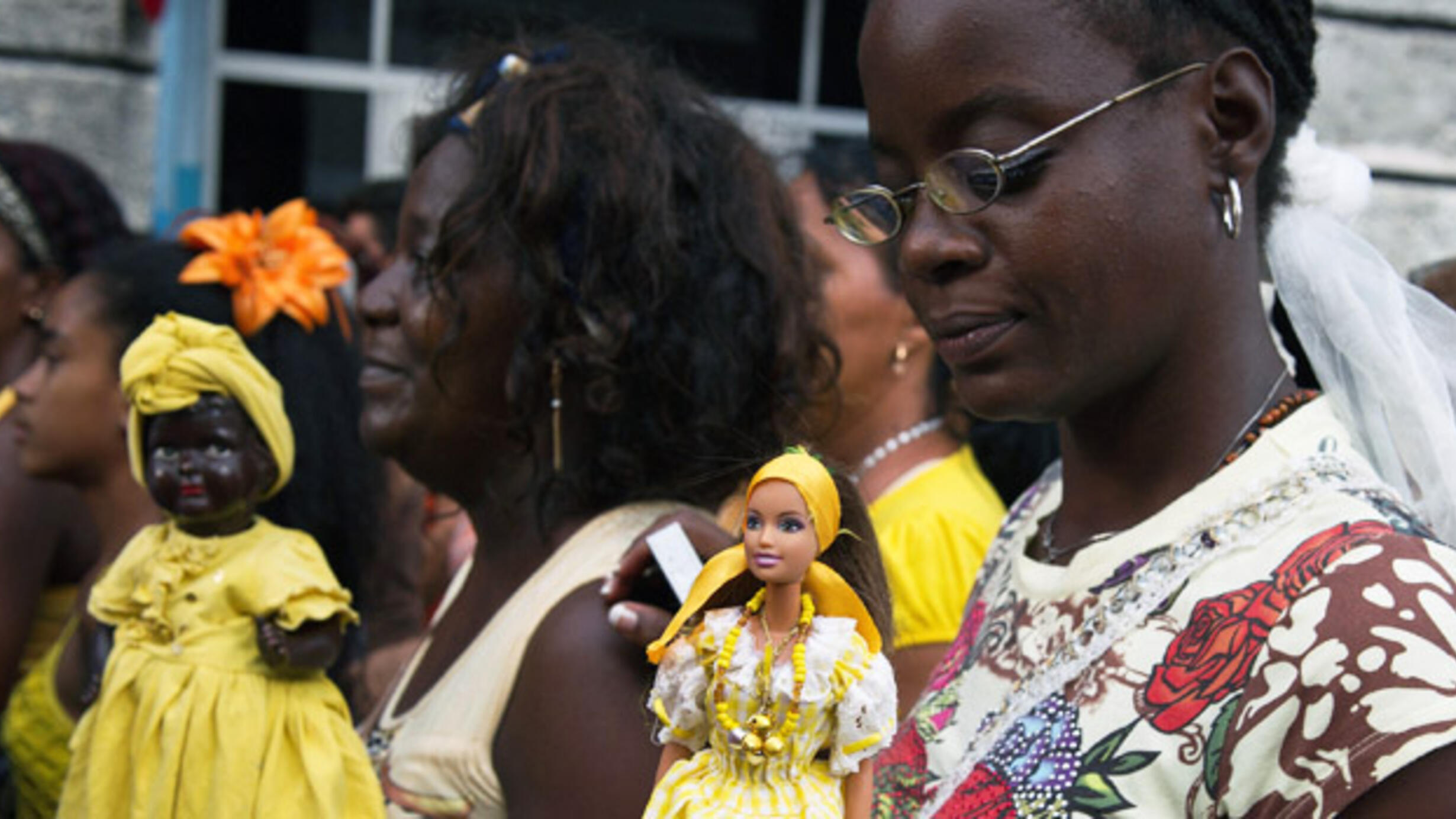 A group of women carry dolls dressed to represent Oshun.