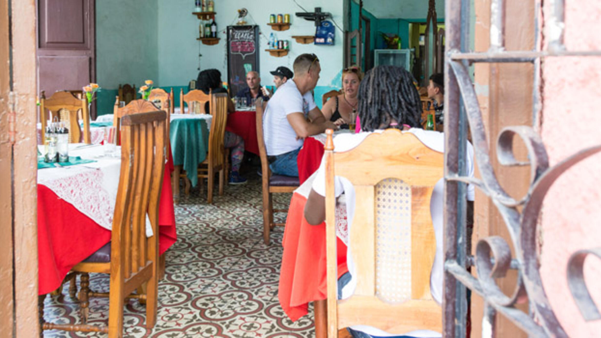 Customers sit at tables talking and eating.