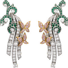 Diamond and emerald earrings with three curved strains of diamonds emerging from branchlike design and two, small diamond butterflies on each earring.