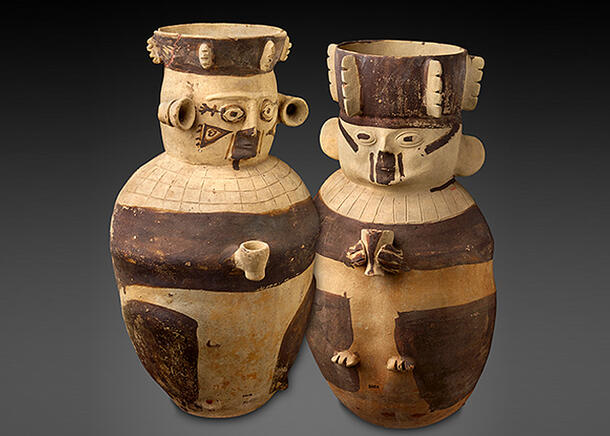 Two rounded vessels with open tops are decorated with human details including faces and small hands holding tiny cups.