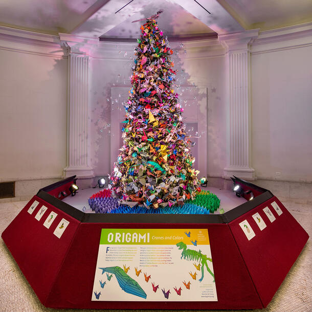 The 2020 Origami Holiday Tree is displayed on a pedestal in the Museum's Grand Gallery.