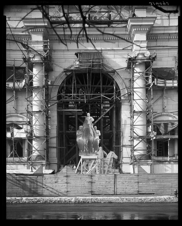 Scaffolding and fencing surround a wooden mockup of the Theodore Roosevelt Equestrian statue.