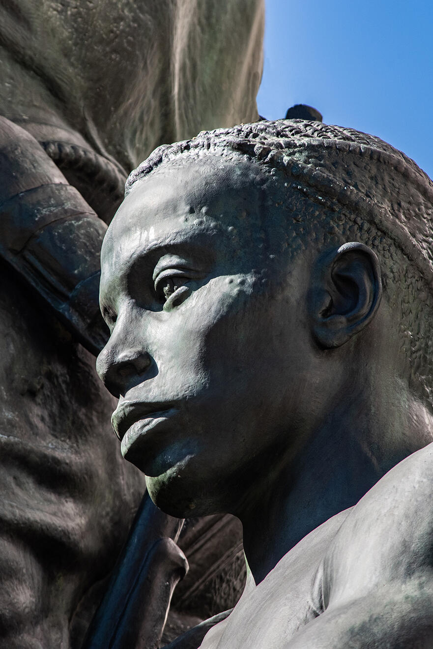 Detail of the face and head of the African figure in the Roosevelt Statue.