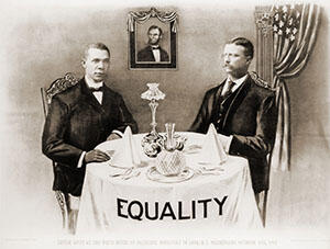 Booker T. Washington (left) and Theodore Roosevelt (right) are seated at a small round table that is set for dinner.