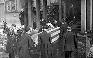 Six pallbearers carry a coffin draped in an american flag, which contains the remains of Theodore Roosevelt.