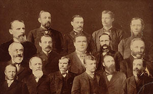 A group portrait with Theodore Roosevelt seated with fifteen other members of the New York State Assembly.