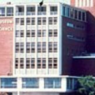 The exterior of a large modern building with rows of square windows.