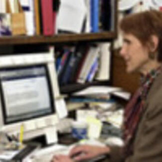 A woman seated before a computer.