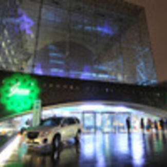 An exterior view of the Museum's 81st Street entrance, at night, showing the six-story glass cube enclosing the Hayden Sphere.