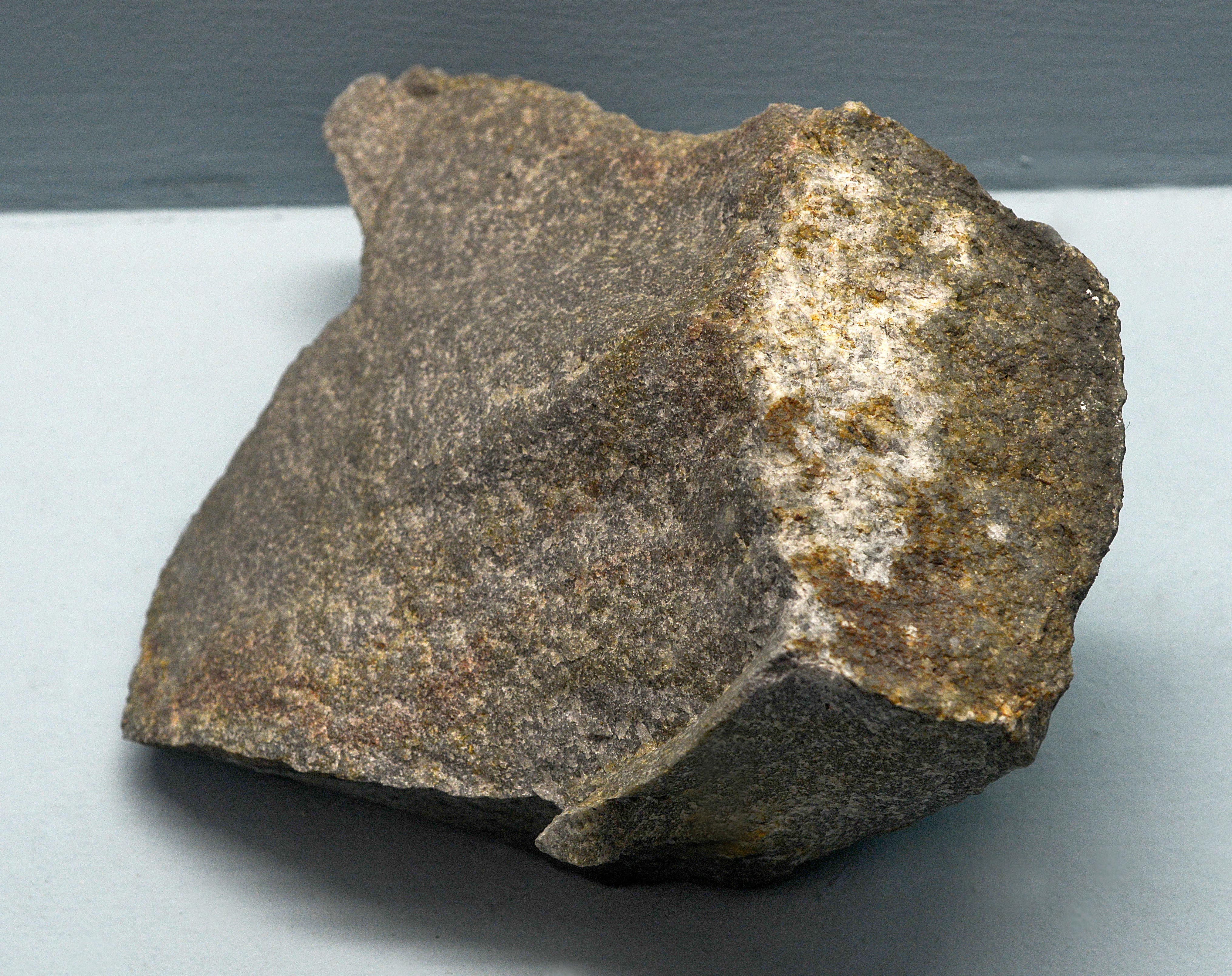 An irregularly shaped piece of quartzite modified sandstone.