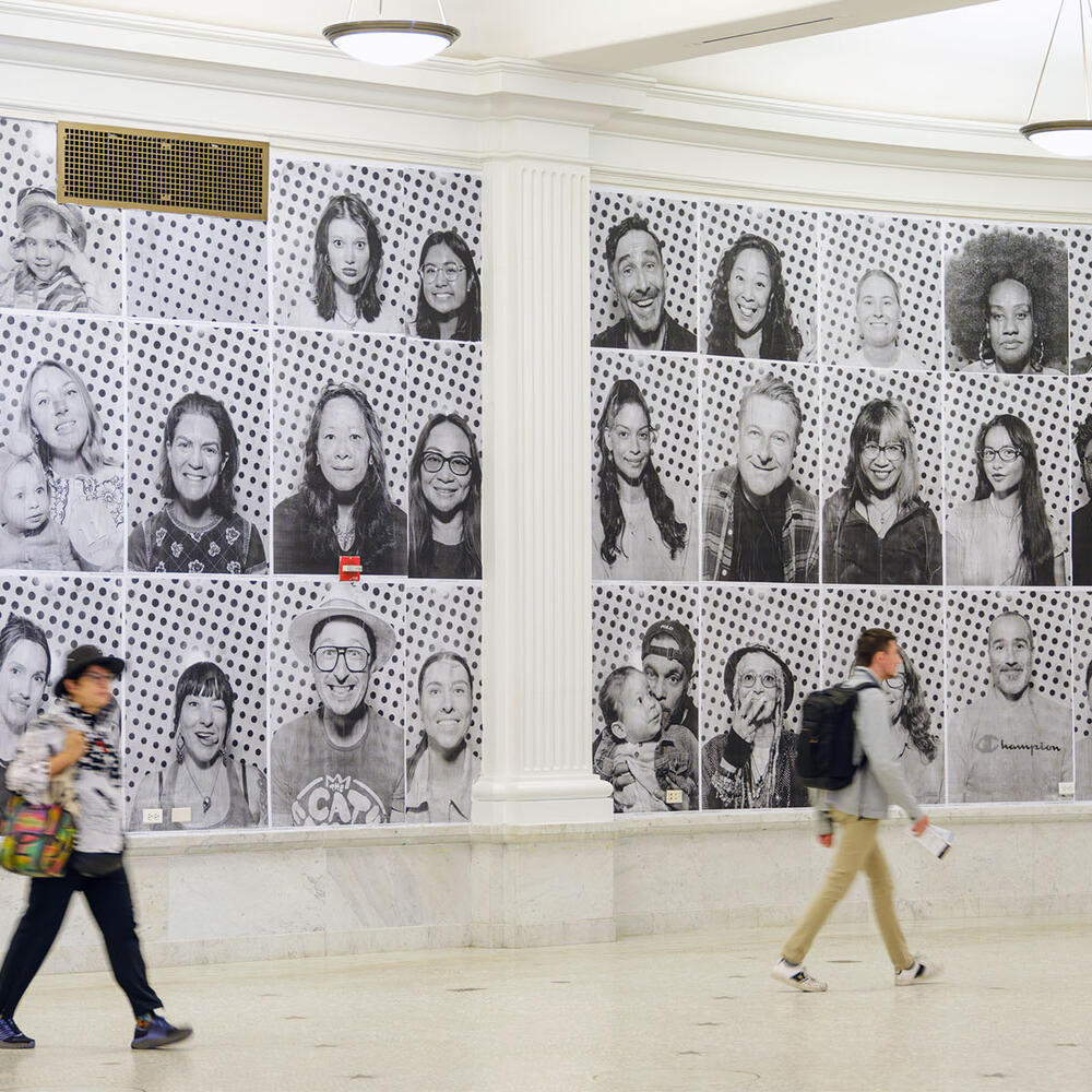 Museum visitors walk past the larger-than-life photographic portraits that are mounted on all of the walls within the Ellen Futter Gallery.
