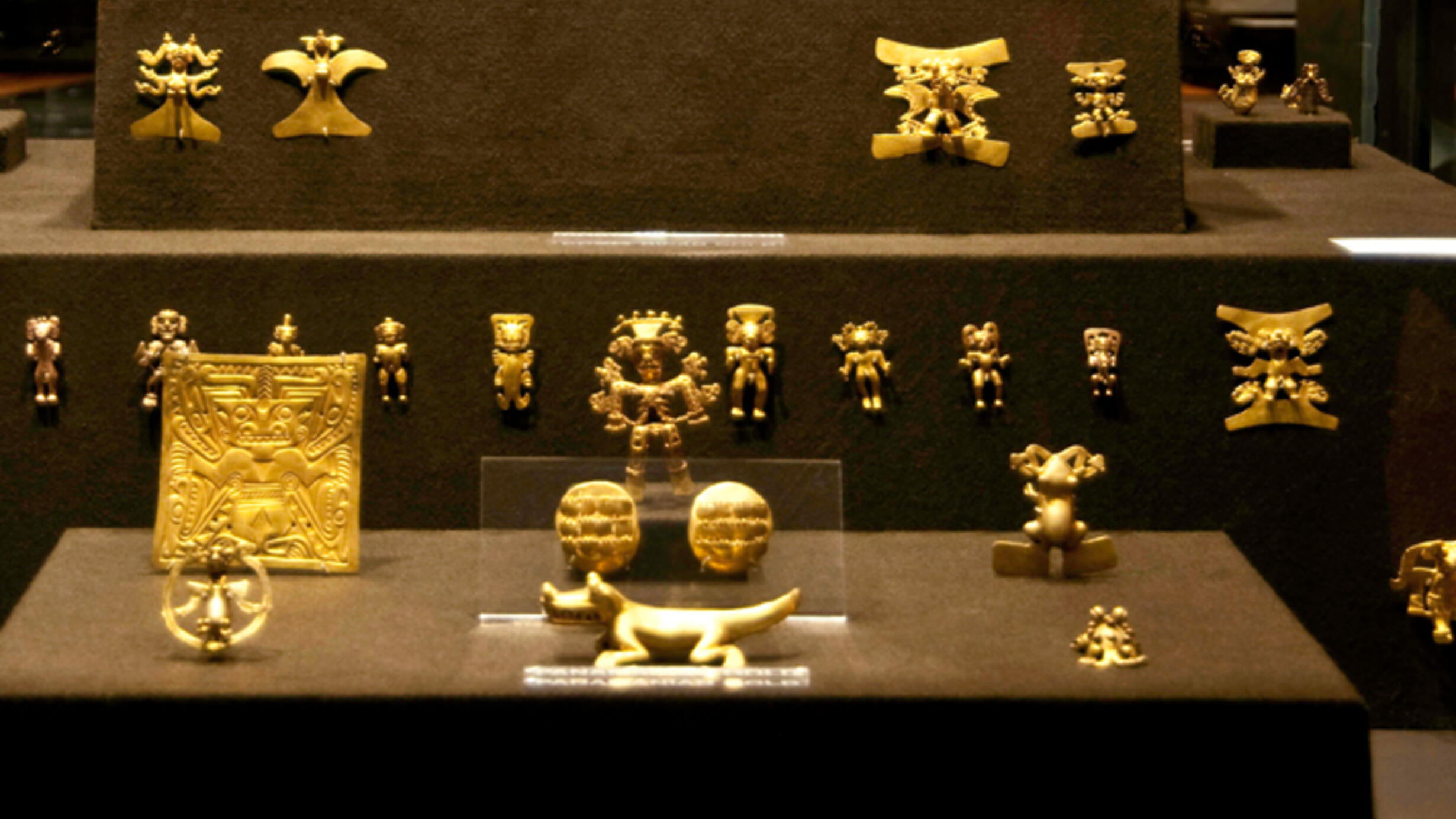 In the Museum’s Hall of Mexico and Central America, an exhibition case with multiple small figurines and articles made from gold.