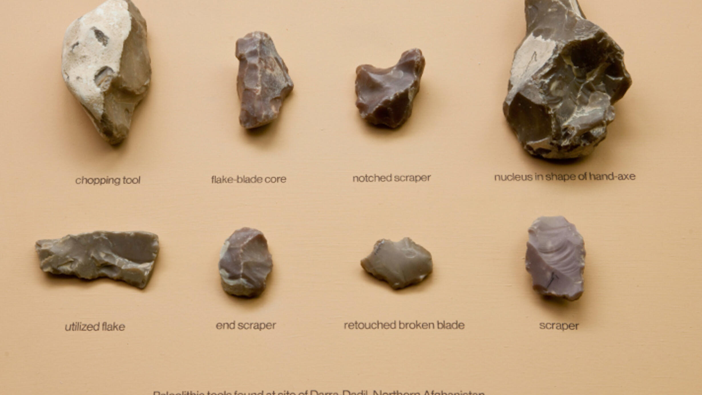A display of eight small chipped-stone tools.