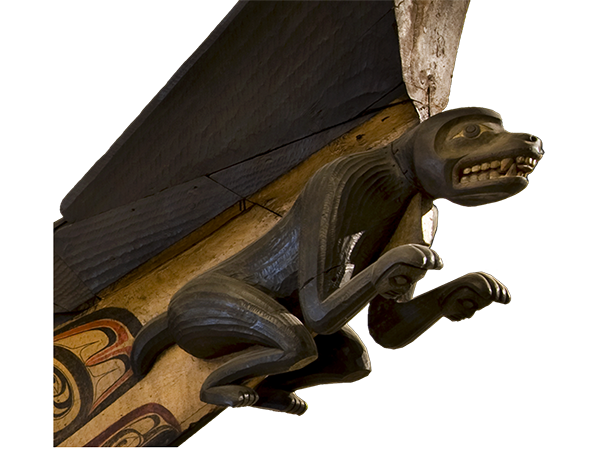 The prow of a canoe is carved in the shape of a crouching wolf with its teeth barred.