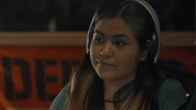 Woman wearing over-ear headphones pictured from shoulders up. 