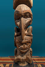 Carved wooden totem pole depicts a raven and a human and is located inside the Museum's Northwest Coast Hall.