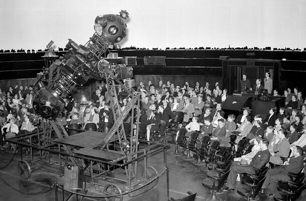 A packed audience seated around the original Zeiss projector watch the space show in the Hayden Planetarium.