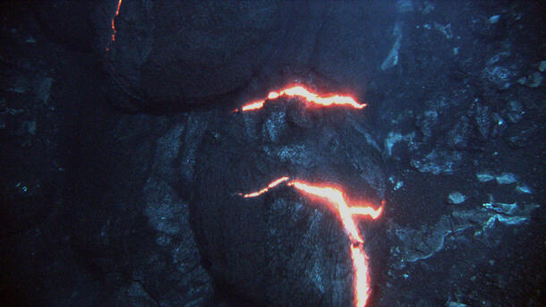 Large dark stones with thin cracks that glow bright from seeping magma.