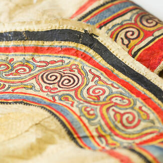 Close up of fish skin robe with intricate, multi-colored design.