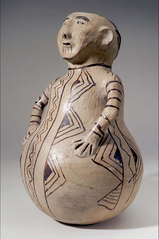 Effigy pot shaped like a person or other figure, with painted features and geometric designs.