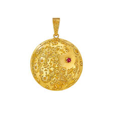 A pendant charm shaped like the moon with pockmarks and a single ruby stud marking the 1969 Moon landing spot.