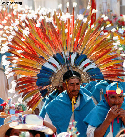 A performer wearing a large, colorful headdress.