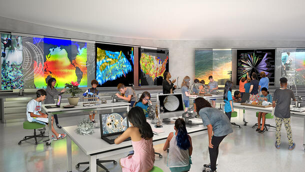 Rendering shows an open space with students and teachers surrounded by desktop and wall-mounted digital screens displaying bright visuals.