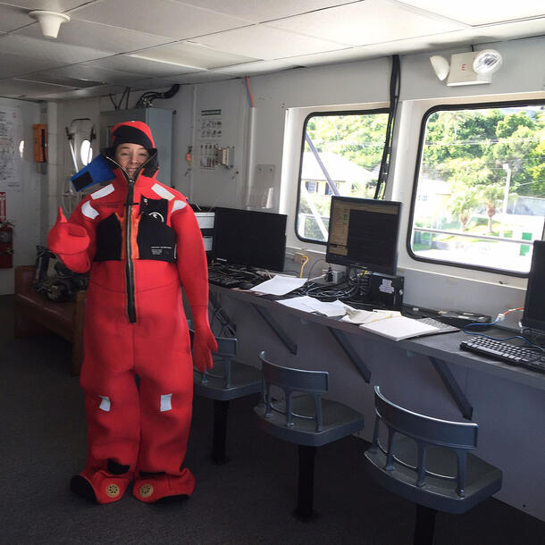 Paasch stands inside a research vehicle wearing a puffy, full-body suit.