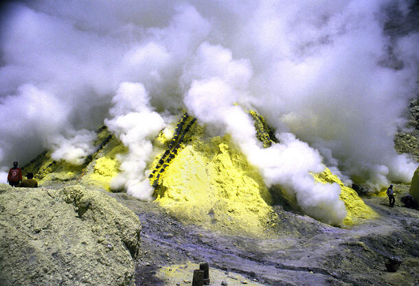 Steam rises from large pile of sulfur.