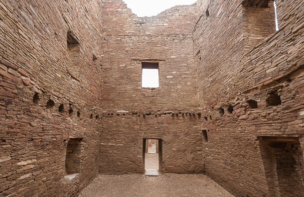 View from inside the remains of a sandstone structure shows window and door openings and evidence of a second story.