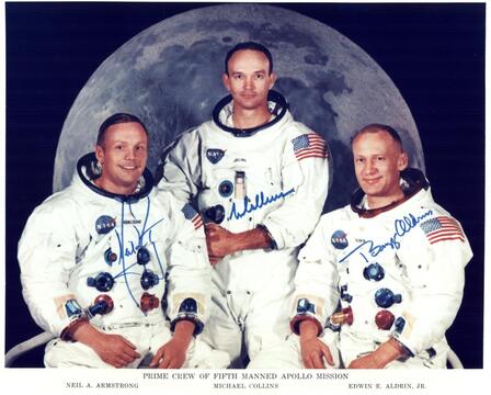 Ο Neil Armstrong, ο Michael Collins και ο Edwin "Buzz" Aldrin θέτουν για ένα πορτραίτο που φορούν τα κοστούμια τους χωρίς τα κράνη τους. Ο Ντιλ Άρλστρονγκ, ο Μιχαήλ Γ