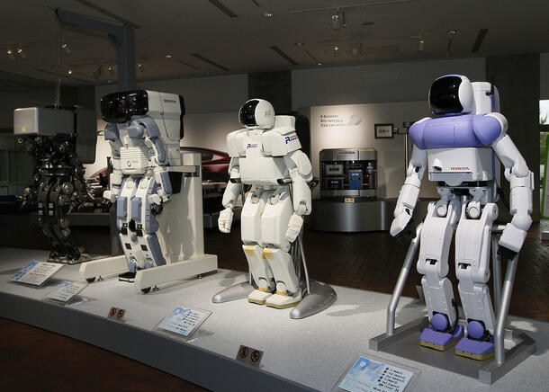 Three humanoid robot prototypes are displayed standing side-by-side.