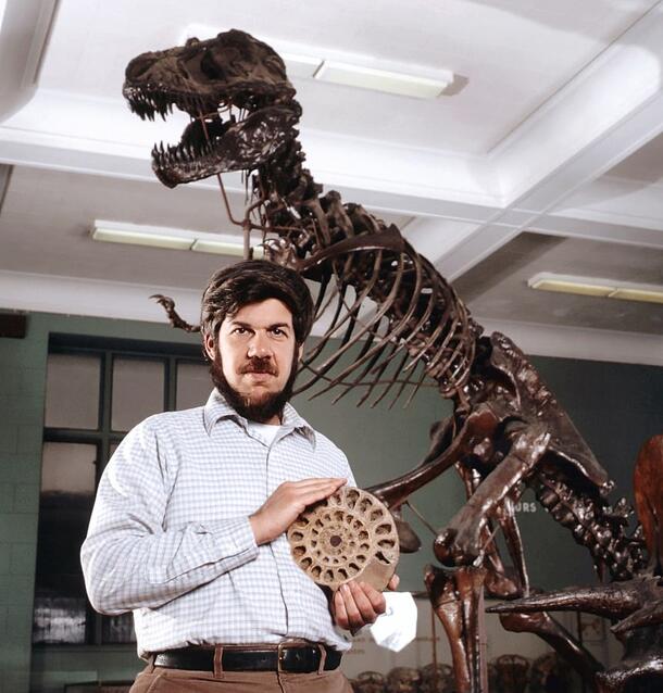 Evolutionary biologist Stephen Jay Gould, posing in front of a T-rex fossil model in the American Museum of Natural History.