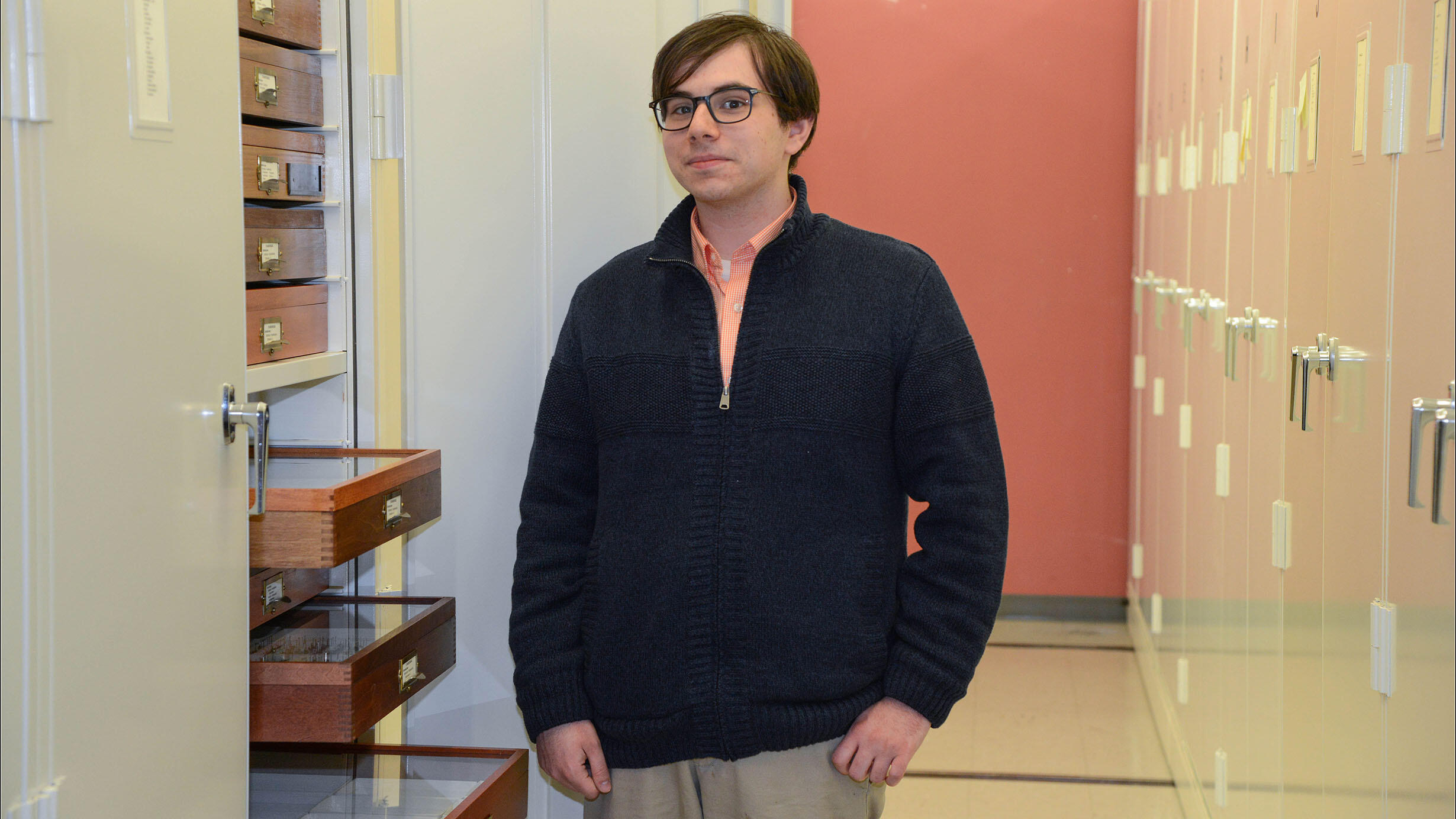 Jeremy Frank stands near collection cabinets.