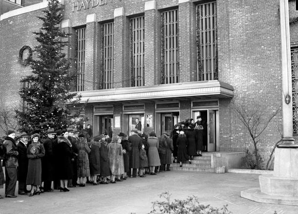 Visitors bundled up in winter coats wait in line outside the Hayden Planetarium.