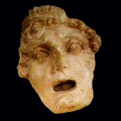 tragic mask carved in limestone