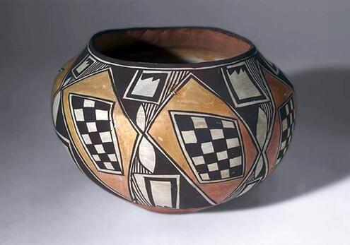clay vase with a rotund body, wide mouth, and checkered design on its sides. 