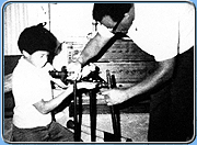 black and white photo of Neil as a child getting a telescope from his dad