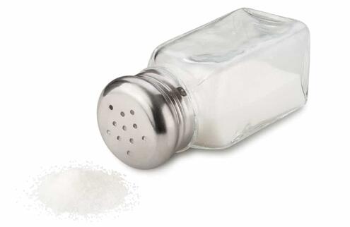 salt shaker tipped next to pile of salt 