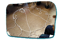 A long piece of string on the ground in a circular, overlapped formation.