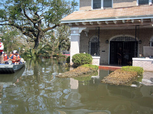 raft of flood rescuers approaching home partially under water