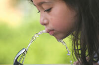 girl drinking from water fountain